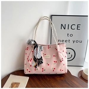 Pink corduroy tote bag with cherry prints, woven rope handles, and decorative scarf detail