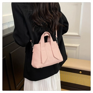 Close-up of pink striped tote bag showing durable texture and bottom metal studs