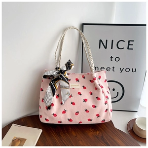 Pink corduroy tote bag detail with red strawberry print and braided rope handles