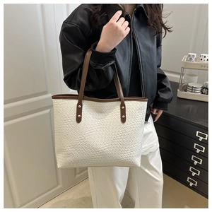 Modern white woven tote bag with brown straps styled on a model for casual daily use