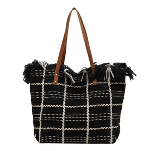 Checkered knit tote bag with black fringe details and brown leather handles