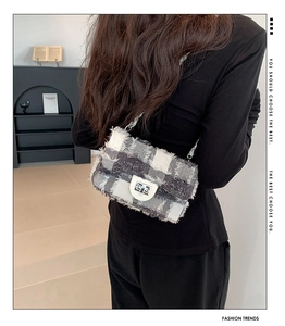 Détail du sac bandoulière à carreaux avec fermoir rotatif argenté et chaîne sur mannequin