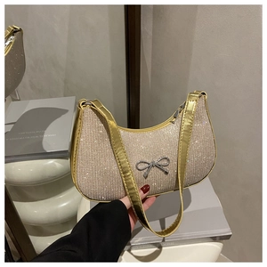 Close-up of champagne gold sequined handbag with a silver metallic bow decoration