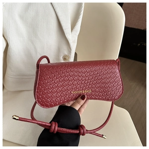 Detail of red woven leather square bag with gold Fashion & Bags lettering and slim strap