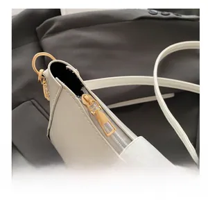 Gros plan du sac bandoulière blanc crème avec fermeture éclair dorée et texture en cuir