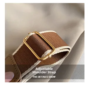 Détail d'une bandoulière en tissu marron réglable avec boucle en métal doré chic
