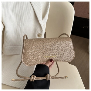 Detail of woven texture on beige small square bag with adjustable shoulder strap