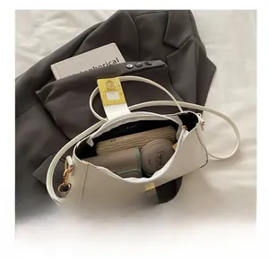 Détail du sac bandoulière en cuir blanc montrant la capacité pour téléphone et portefeuille