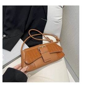 Detailed view of crocodile embossed leather texture on a brown vintage baguette bag