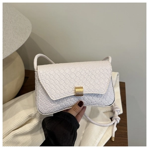 Detailed view of white woven texture leather bag featuring a gold magnetic metal buckle