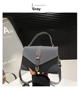 Detail of grey denim texture small square bag with golden U-shaped buckle and top handle