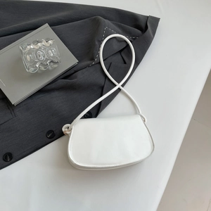 Minimalist white faux leather saddle bag with shoulder strap shown on aesthetic scene