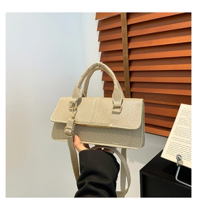 Detail of beige woven fabric texture and gold metal accent on the minimalist handbag