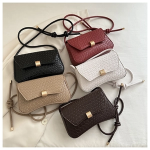 Detail view of rectangular woven texture bags in burgundy, black, white, khaki, and brown