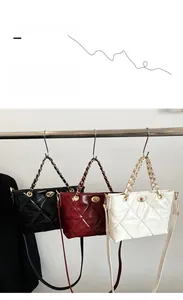 Close-up of quilted tote bags with chain handles and twist lock closure in three colors