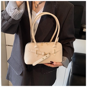 Détail du sac bowling tressé beige avec boucle dorée et bandoulière amovible incluse