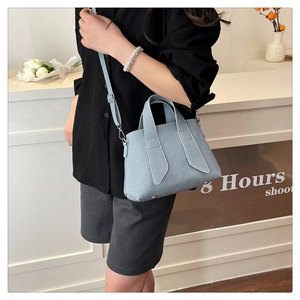 Detailed view of light blue striped tote bag with texture and adjustable shoulder strap