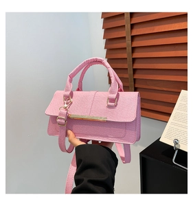 Detail of pink textured fabric small square bag with elegant gold metal buckle accent