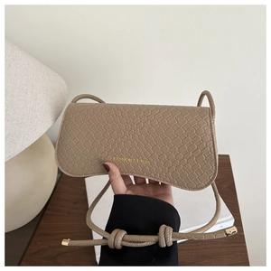 Detail of beige crocodile embossed leather handbag featuring Fashion & Bags logo lettering