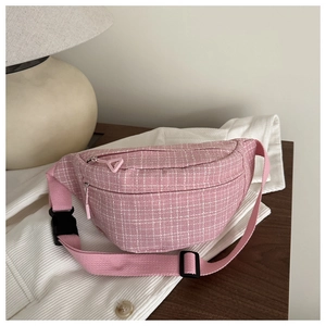 Détail du sac de poitrine en tweed rose à carreaux sur une table en bois chic