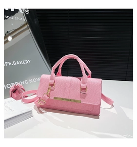Detailed texture of pink fabric shoulder bag with gold metal hardware and chic hand strap