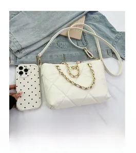 Detailed comparison of the white quilted crossbody bag size with a mobile phone