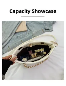 Internal capacity of white quilted shoulder bag showing cosmetics and golden chain detail
