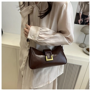 Détail du sac à bandoulière en cuir synthétique marron foncé avec boucle dorée carrée