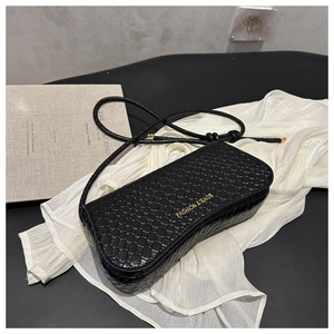 Macro detail of black woven leather texture and golden brand lettering on handbag