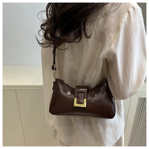 Détail du sac porté épaule en cuir marron foncé vintage avec boucle en métal doré chic