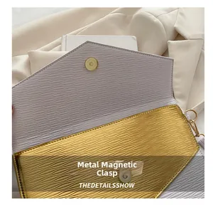 Detailed view of the magnetic metal clasp on an elegant envelope clutch handbag