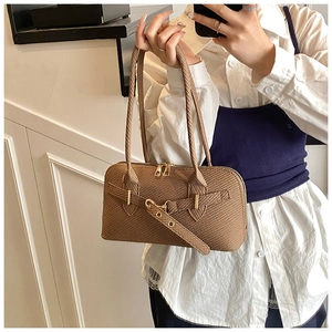 Detail of vintage brown textured underarm bag with gold buckle and long handle
