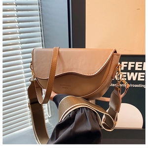 Détail du sac de selle en cuir kaki avec deux bandoulières et inscription mode stylée