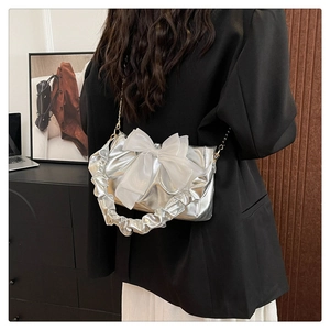 Silver metallic crossbody bag featuring a large white organza bow and ruched handle detail