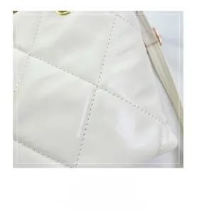 Macro detail of high-quality stitching on quilted beige chain shoulder bag made of PU leather