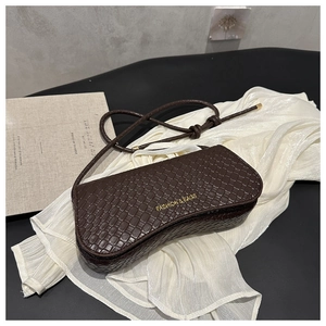 Detail of dark brown faux crocodile leather bag with gold embossed brand lettering