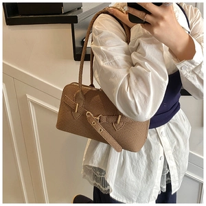Détails d'un sac sous le bras vintage à carreaux marron avec texture tissée et métal doré