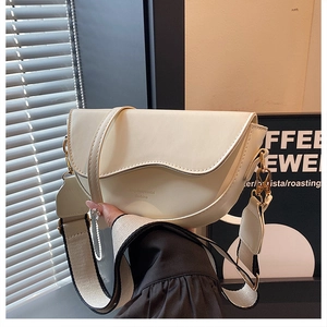 Détail du sac de selle crème avec bandoulière tissée noir et blanc et ferrures dorées