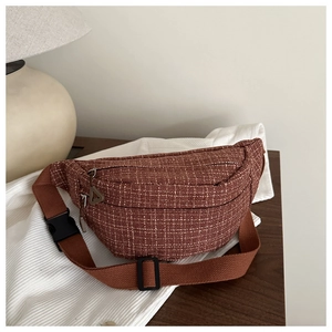 Gros plan sur un sac de poitrine en tweed à carreaux marron avec sangle réglable