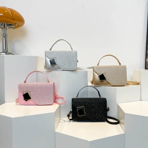 Bolsos de noche brillantes en plata, oro, rosa y negro expuestos en estantes