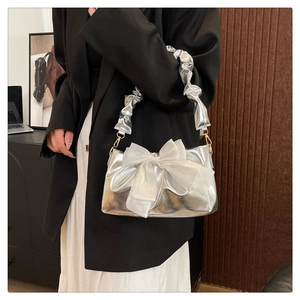 Silver metallic shoulder bag featuring a large white organza bow and ruched strap