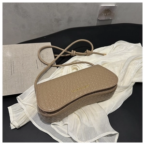 Detail of khaki crocodile pattern crescent bag with golden text and knotted straps