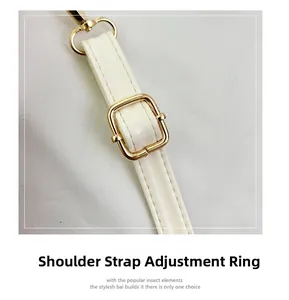 Detail of adjustable cream leather shoulder strap with gold buckle and stitching