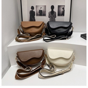 Close-up of four saddle bags with wave-edge flaps and wide fabric straps in a Nordic setting