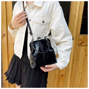Detailed close-up of a vintage black glossy leather doctor bag with metallic ball clasp