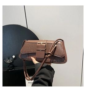 Close-up of deep brown crocodile texture leather bag with large square metal buckle