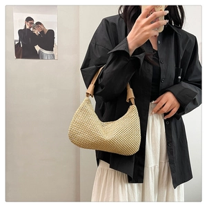 Detail der handgewebten beige Hobo-Tasche mit braunem Lederriemen am Model