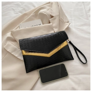 Detail of black epi leather envelope clutch with V-shaped gold metal clasp and wrist strap
