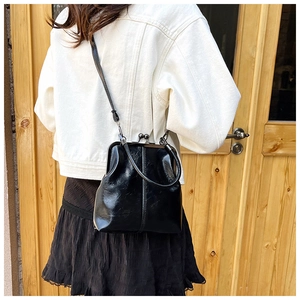 Detail of vintage glossy black doctor bag with metallic frame closure and leather strap