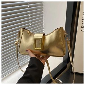 Détail du sac à bandoulière doré métallisé avec grande boucle et finition miroir brillante